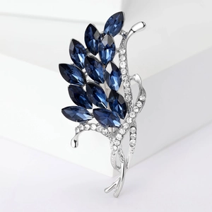 Detail of leaf brooch with dark blue marquise crystals and pavé set white zircons
