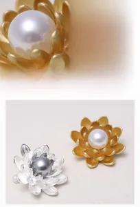 Detailed view of matte flower brooches with faux shell pearls in gold and silver finish