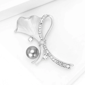 Détail de la broche feuille de ginkgo argent mat avec perle grise et strass brillants