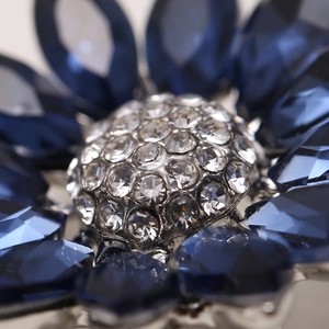 Exquisite flower brooch featuring dark blue crystal petals and sparkling white rhinestones