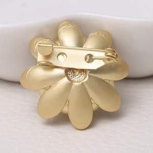 Matte gold floral brooch back view featuring a secure pin clasp on metal flower petals