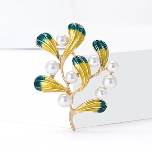 Eleganter Blatt-Brosche in Gold mit Perlen und grünem Emaille-Verlauf auf weißem Podest