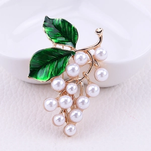 Détail macro de l'élégante broche en forme de raisin avec perles et feuilles d'émail