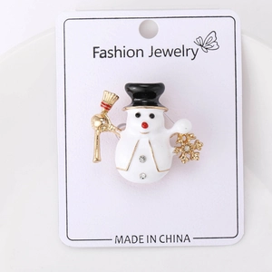 Detailed close-up of a Christmas snowman brooch with white enamel and rhinestone accents