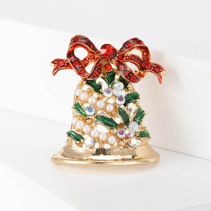 Vue détaillée d'une broche cloche de Noël avec strass rouges et décorations en émail