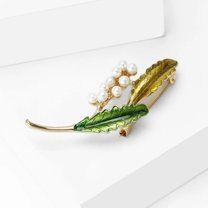 Broche élégante en forme de plante avec émail vert, placage or et perles blanches