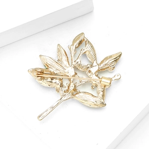 Detailed back view of gold plant brooch featuring the safety pin clasp and metal texture