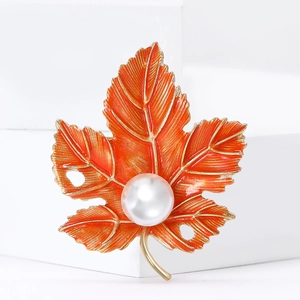 Elegant maple leaf brooch in orange enamel with gold plating and white pearl accent