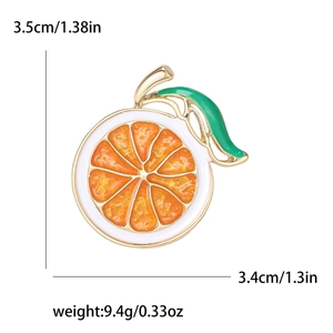 Cartoon orange slice enamel brooch with green leaf and gold trim measuring 3.5cm by 3.4cm