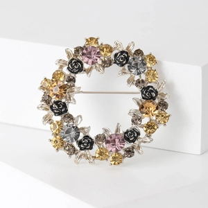 Elegante spilla floreale rotonda con cristalli champagne e rose nere su supporto