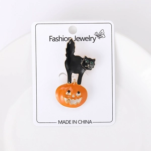 Détail de la broche d'Halloween chat noir sur citrouille avec des yeux en pierre verte