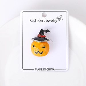 Detail of pumpkin brooch with wizard hat and sparkling crystals on jewelry card