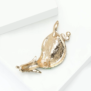Detailed back view of gold-plated brooch with safety pin fastener and crystal accents