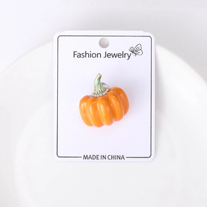 Detail of pumpkin brooch with orange enamel finish and sparkling white rhinestones