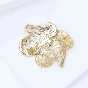 Vue détaillée de l'arrière d'une broche gant de Noël dorée avec un fermoir de sécurité