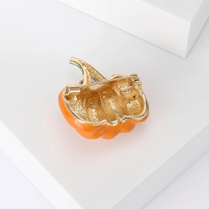 Back view of orange pumpkin brooch with golden alloy pin on white display stand