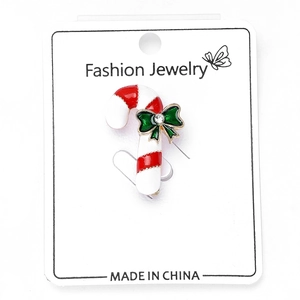 Detailed view of enamel candy cane brooch with green rhinestone bow on display card