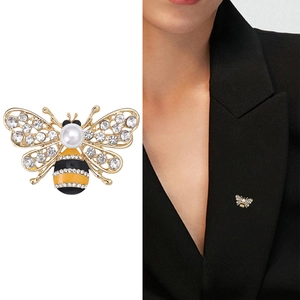 Broche abeille dorée avec perles blanches et zircons sur un costume noir