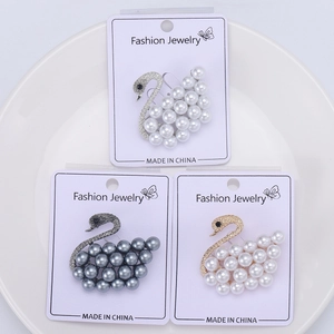 Detailed set of three swan pearl brooches in white, dark grey and pink purple on cards