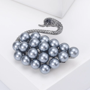 Detail of swan brooch featuring greyish blue pearls and pave-set crystals on silver metal