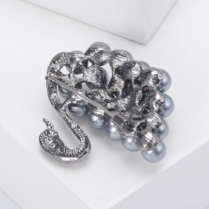 Detail view of swan brooch back mechanism with industrial metal texture and safety pin