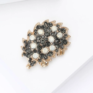 Macro shot of a detailed vintage hedgehog brooch with grey rhinestones and gold plating