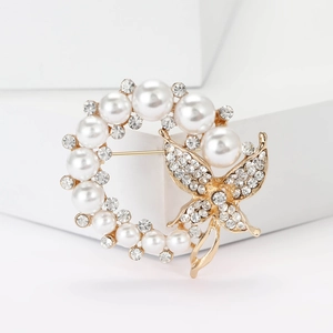 Eleganter Gold-Schmetterling-Brosche mit Perlen und Kristallen auf weißem Hintergrund