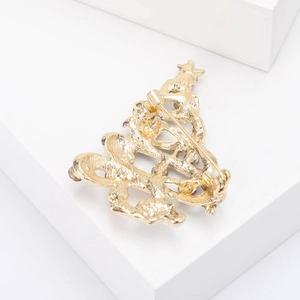 Detailed back view showing the golden alloy clasp and pin of the Christmas tree brooch