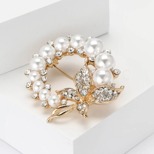 Eleganter Gold-Kranz Brosche mit Perlen und Straßsteinen auf minimalistischem Ständer
