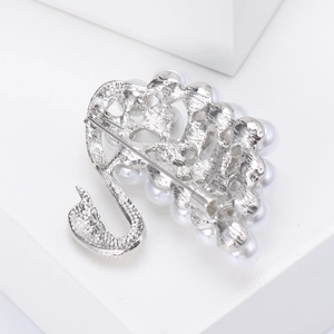 Elegant swan brooch with white pearls and silver alloy base shown from a side-back view
