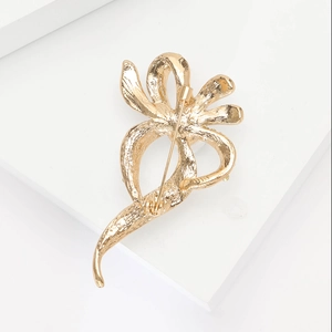 Détail de la broche fleur dorée avec texture martelée et fermoir à épingle de sécurité