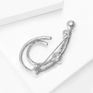 Detailed back view of a silver hollow brooch with pearls and refined metal texture