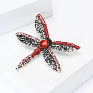 Detailed macro view of dragonfly brooch with red rhinestones and hollow filigree wings