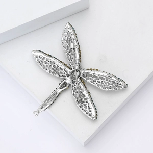 Detailed macro view of dragonfly brooch with hollow metal wings and colorful rhinestones