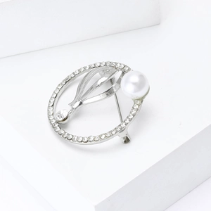 Elegante zilveren ronde broche met strassteentjes en witte parel op wit blok