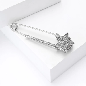Dettaglio della spilla a stella d'argento con cristalli pavé su un blocco geometrico