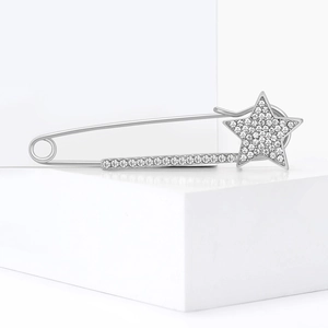 Spilla a forma di stella d'argento con strass bianchi su supporto bianco moderno
