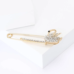 Elegant gold swan brooch with sparkling crystals on a minimalist safety pin design