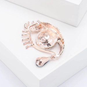 Dettaglio del retro della spilla a forma di occhio in oro rosa con chiusura a spilla sicura