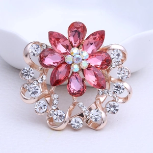 Détail macro d'une broche fleur avec cristaux roses et cadre en plaqué or rose brillant