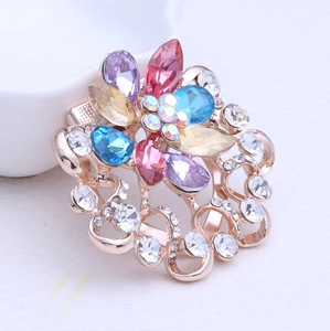 Vue macro d'une broche fleur en strass colorés avec détails plaqués or rose
