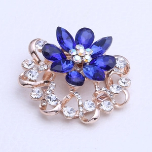 Détail de la broche fleur en or rose avec pétales en cristal bleu et sertissage de diamants