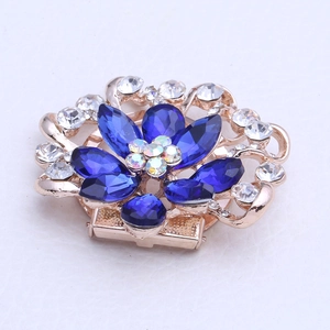 Détail de broche fleur avec pierres marquises bleues et strass arc-en-ciel