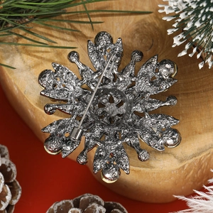 Vintage gunmetal floral brooch with full crystals on a festive winter background