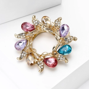 Detailed close-up of a floral silk scarf buckle with colorful drop-shaped gemstones and crystals