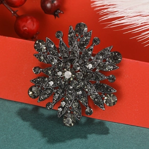 Vintage gun-black flower brooch with grey rhinestones on festive holiday background