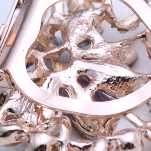 Vue macro détaillée de l'artisanat évidé en or rose au dos de cette attache de foulard