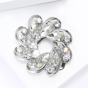 Detailed close-up of a flower-shaped brooch with silver metal and sparkling crystals