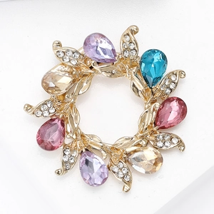 Macro detail of floral wreath brooch with colorful teardrop gems and sparkling rhinestones