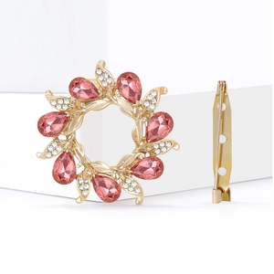 Detailed back view of gold flower brooch showing pin fastening and pink crystal settings
